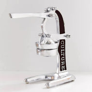 Chrome citrus juicer with black handle and wide feet base, featuring lever arms and rounded pressing bowl.